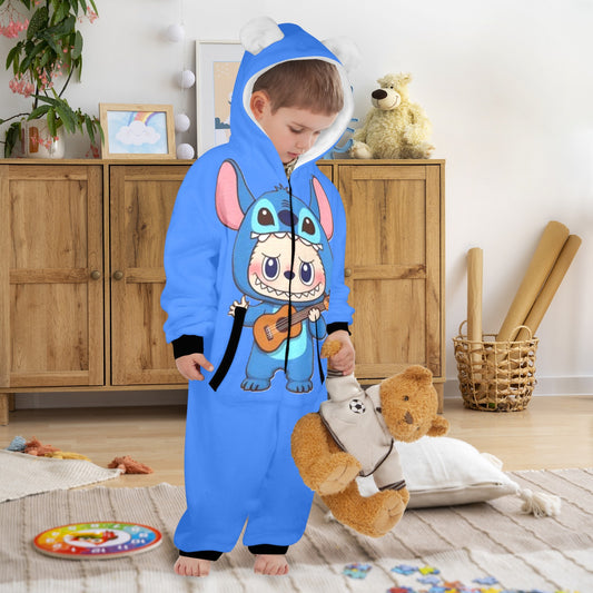 Child wearing a blue onesie with cartoon character design, holding a teddy bear in a room.