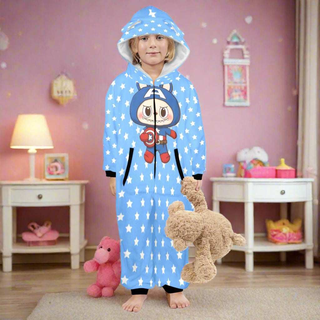Child wearing a blue onesie with a cartoon character, holding a teddy bear on a white background