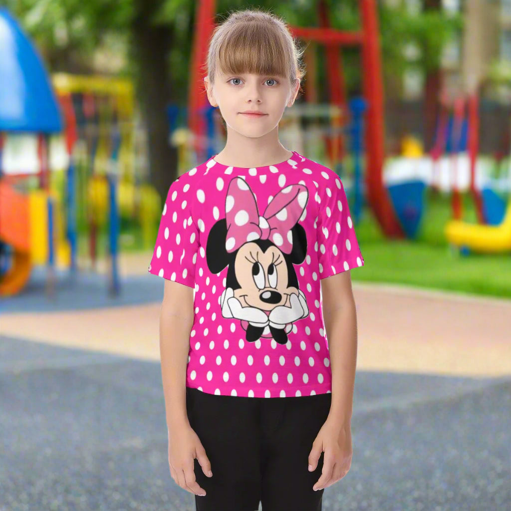 Child wearing a pink polka dot shirt with a cartoon character on a white background