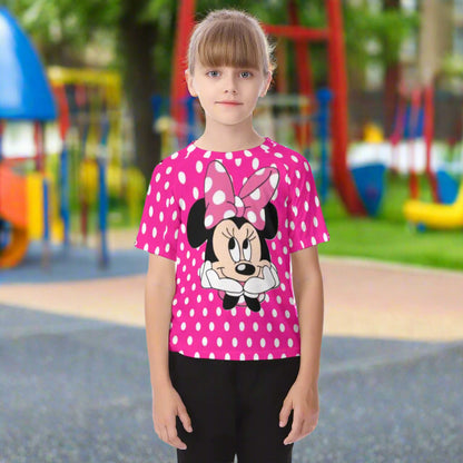 Child wearing a pink polka dot shirt with a cartoon character on a white background