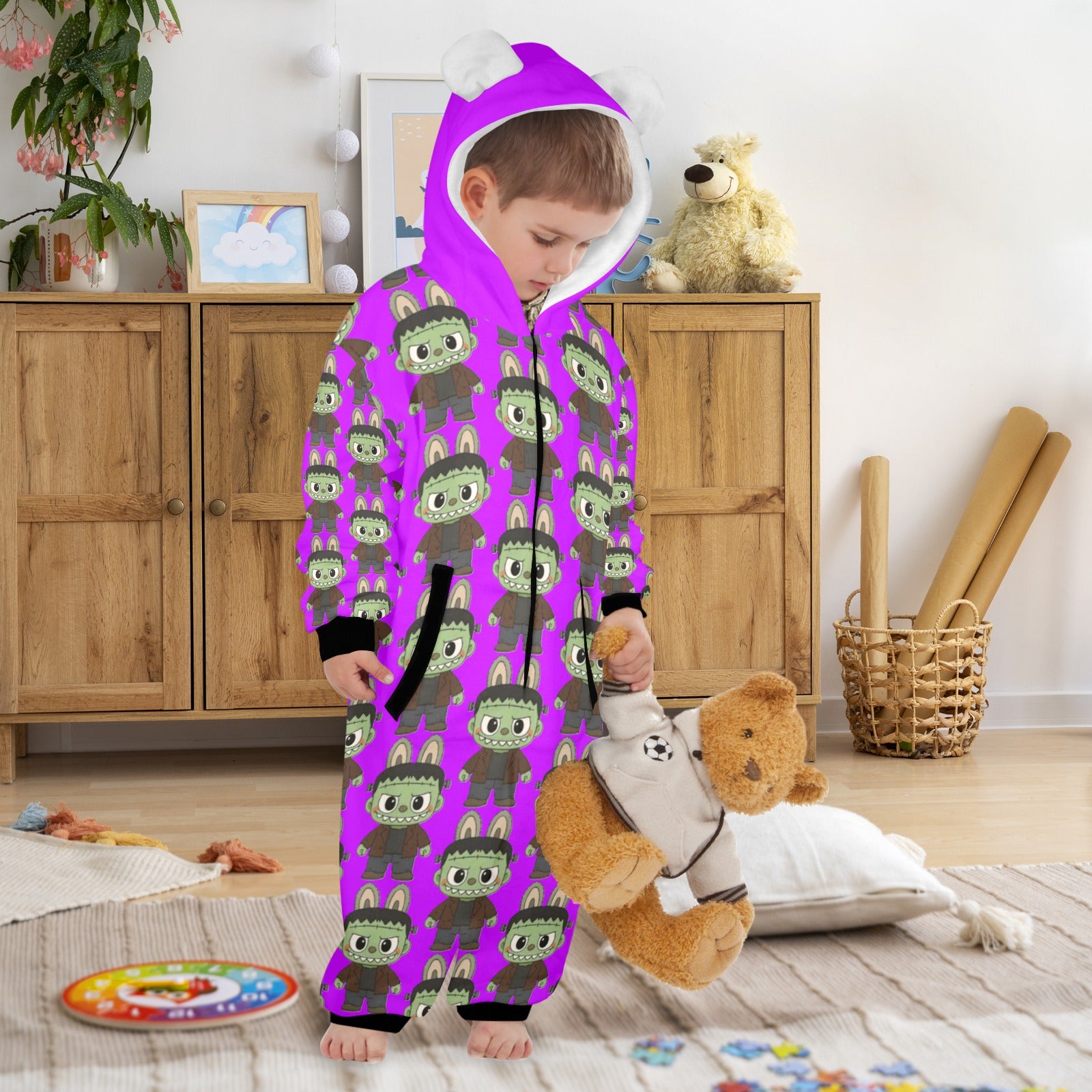 Child wearing a purple onesie with green patterns in a room with wooden furniture and toys.