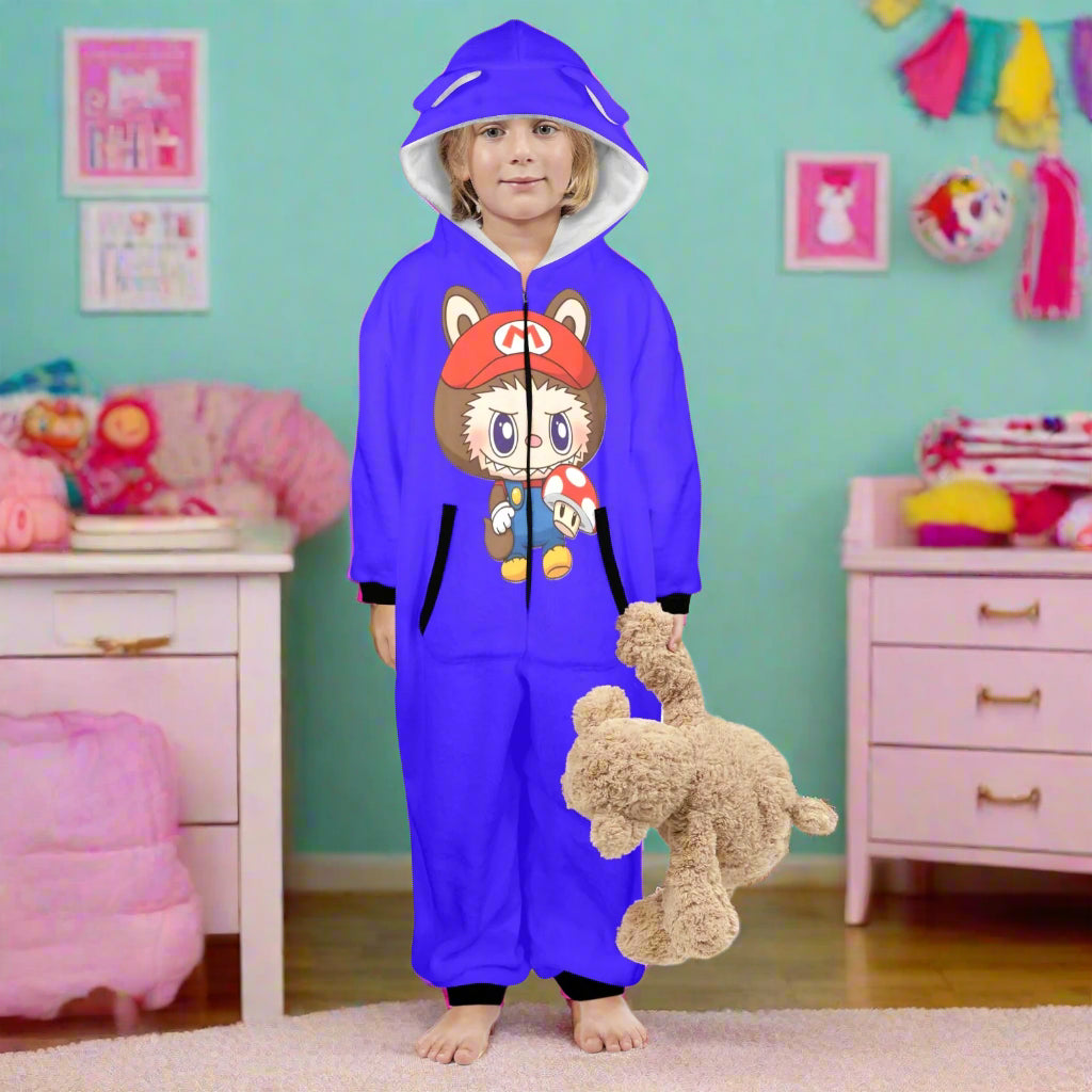 Child wearing a blue onesie with a cartoon character, holding a plush toy on a white background