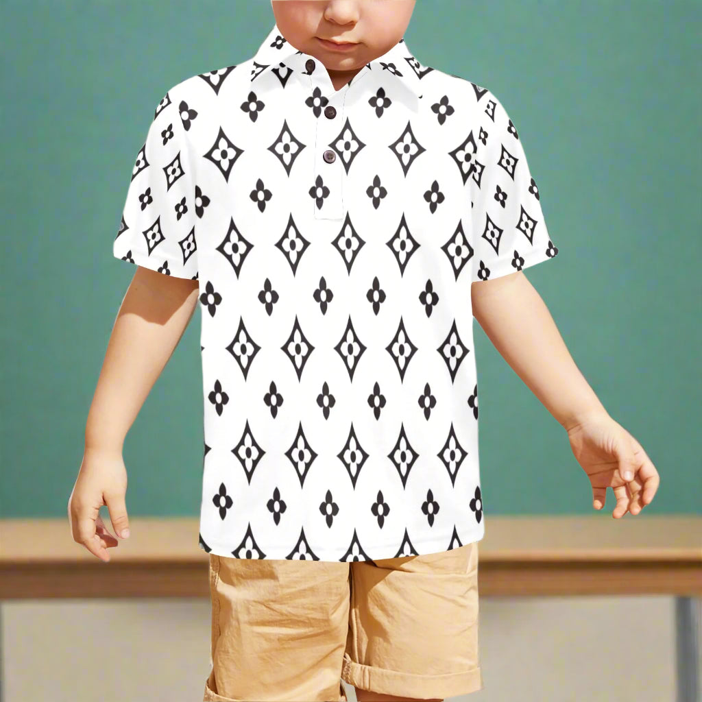 Child wearing a white shirt with black geometric pattern and beige shorts on a white background